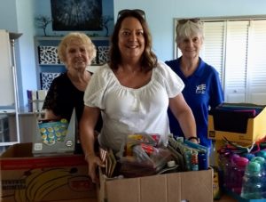 Photo of 2 Chapter Members Presenting School Supplies for Community Classroom